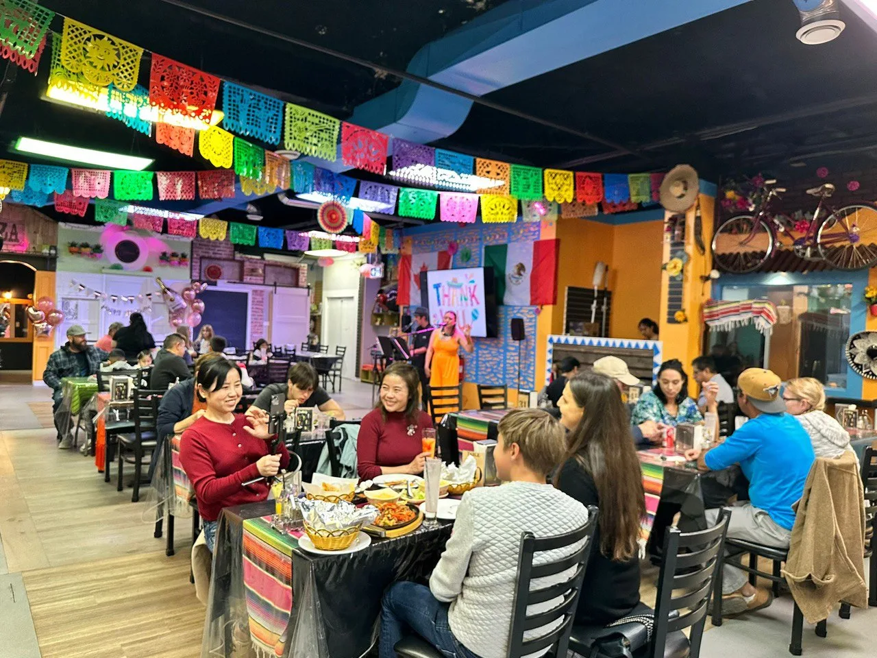 Tenoch's colorful, vibrant dining room with papel picado and a full house