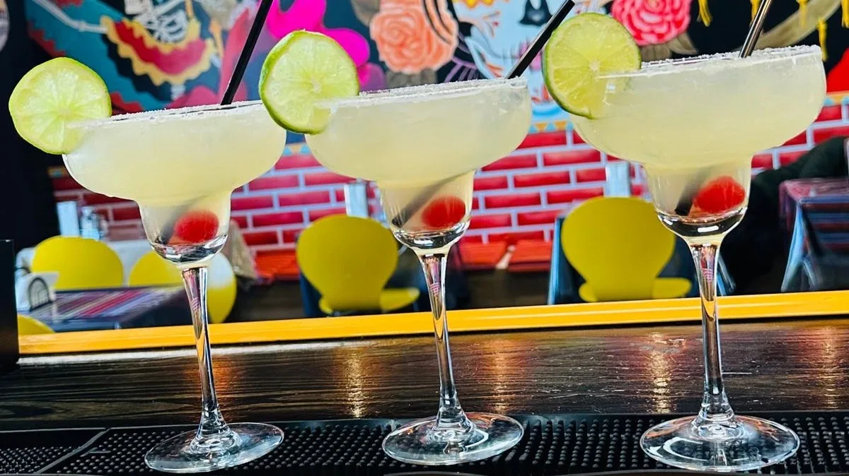 Three margaritas on the bar at Tenoch with a Day-of-the-Dead mural